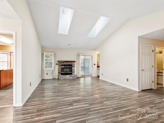 416 Hunters Glen Ln, Hendersonville, NC 28739 - unfurnished living room featuring wood finished floors, vaulted ceiling with skylight, and a healthy amount of sunlight