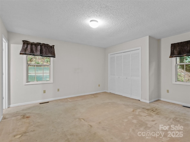 416 Hunters Glen Ln, Hendersonville, NC 28739 - unfurnished bedroom featuring carpet flooring, a textured ceiling, baseboards, visible vents, and a closet
