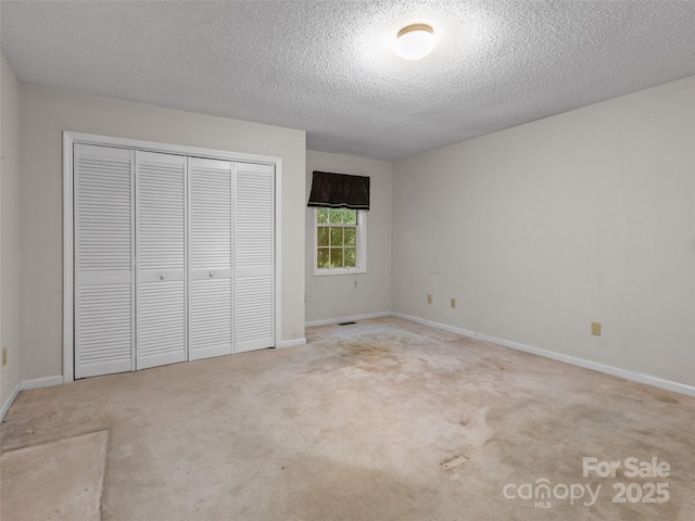 416 Hunters Glen Ln, Hendersonville, NC 28739 - unfurnished bedroom with carpet flooring, a textured ceiling, baseboards, and a closet