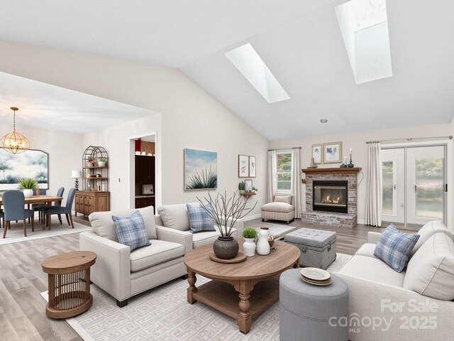 416 Hunters Glen Ln, Hendersonville, NC 28739 - living area with light wood-type flooring, vaulted ceiling with skylight, a fireplace, and an inviting chandelier