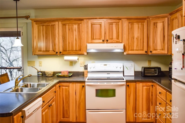 kitchen with sink, white appliances, and decorative light fixtures