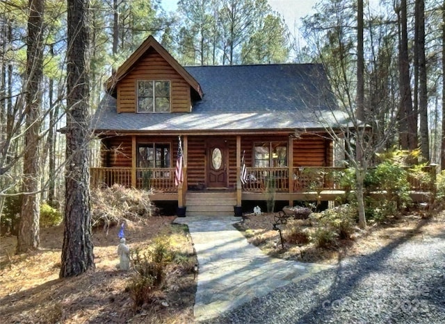 log-style house featuring a porch and a shingled roof