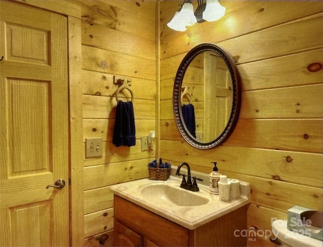 half bathroom featuring wood walls, vanity, and toilet