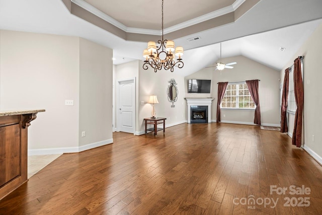 unfurnished living room with a raised ceiling, wood-type flooring, ornamental molding, and ceiling fan