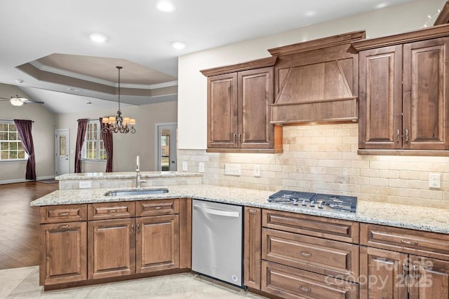 kitchen with stainless steel appliances, kitchen peninsula, sink, and custom range hood