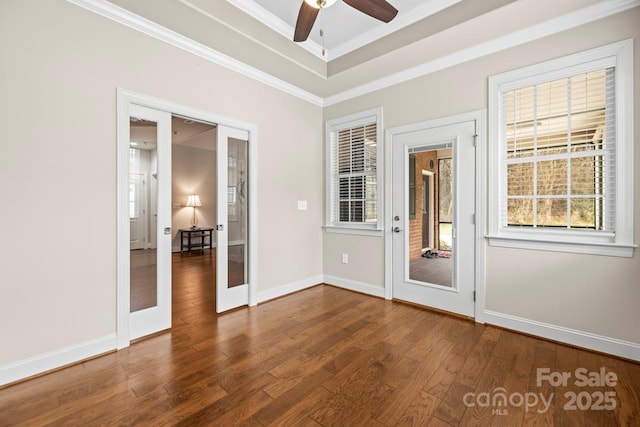 unfurnished room featuring dark hardwood / wood-style flooring, ceiling fan, a raised ceiling, crown molding, and french doors