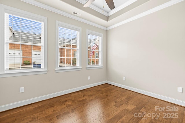 spare room with hardwood / wood-style floors, crown molding, a raised ceiling, and ceiling fan