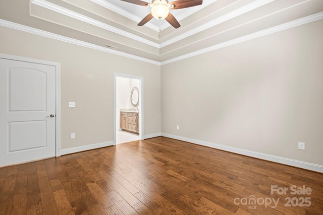 empty room with hardwood / wood-style floors, crown molding, a raised ceiling, and ceiling fan