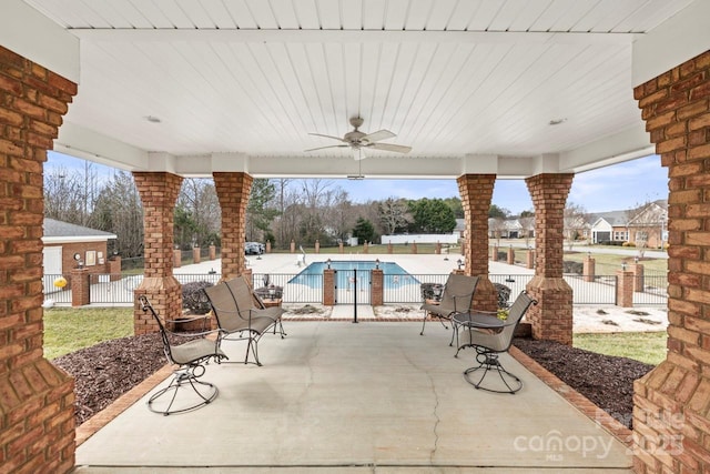 view of patio with a fenced in pool and ceiling fan