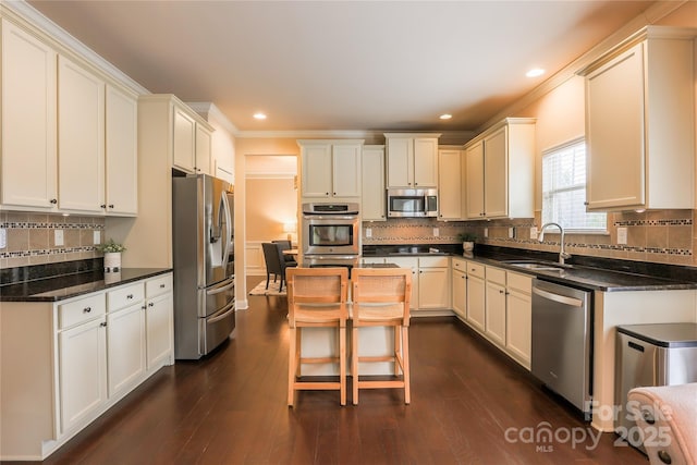 kitchen featuring sink, crown molding, a center island, appliances with stainless steel finishes, and dark hardwood / wood-style flooring