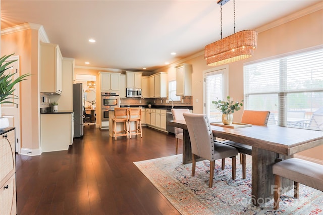 dining area with a wealth of natural light, ornamental molding, and dark hardwood / wood-style floors