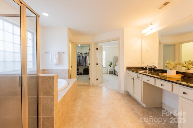 bathroom with vanity, tiled bath, and tile patterned floors