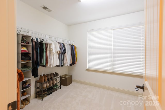 spacious closet featuring light carpet