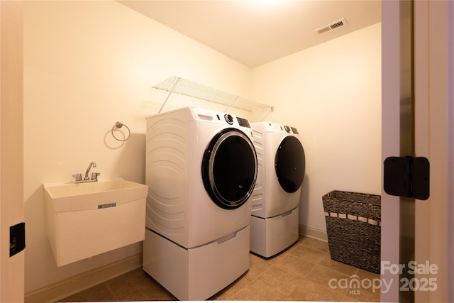 laundry room featuring independent washer and dryer, sink, and light tile patterned floors