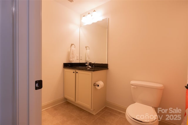 bathroom featuring vanity, tile patterned floors, and toilet