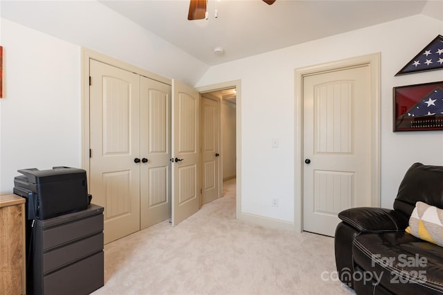 living area with ceiling fan, light colored carpet, and lofted ceiling