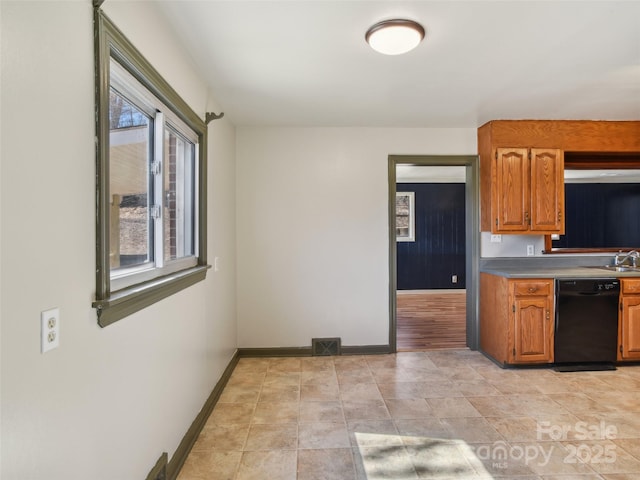 kitchen with a sink, visible vents, baseboards, dishwasher, and brown cabinetry