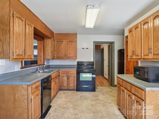 kitchen featuring light tile patterned floors, black appliances, a sink, and brown cabinets