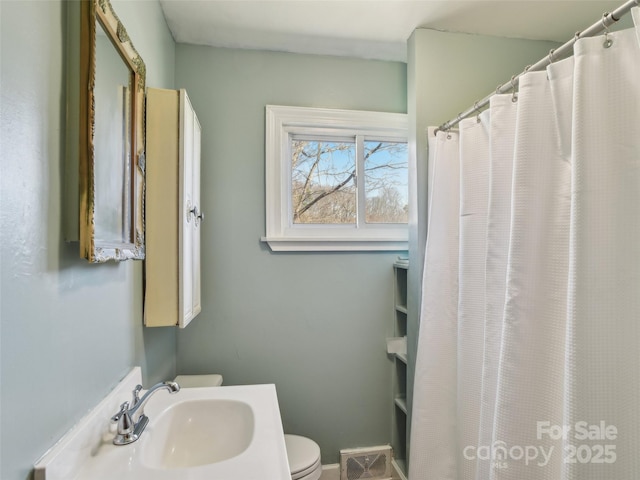 full bath featuring toilet and a sink