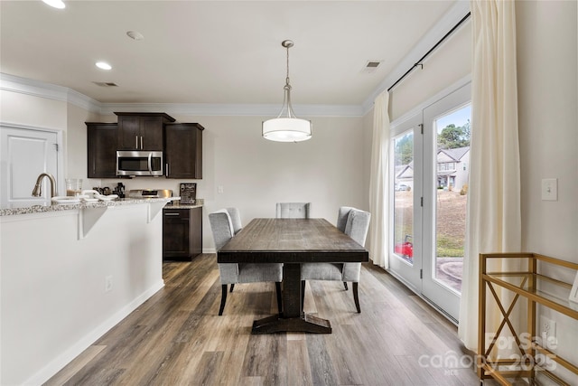 dining area featuring dark wood-type flooring and ornamental molding