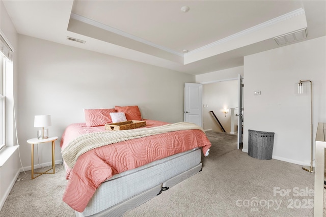 bedroom with light carpet, a tray ceiling, and ornamental molding