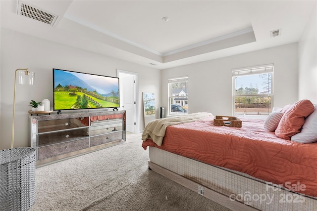 carpeted bedroom featuring crown molding and a tray ceiling