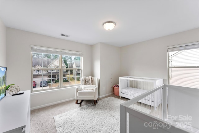 bedroom featuring a crib and carpet flooring