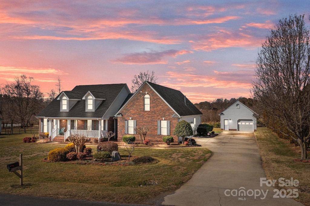144 Cameron Dr, Salisbury, NC 28147 - cape cod house featuring a garage, an outdoor structure, a lawn, and covered porch