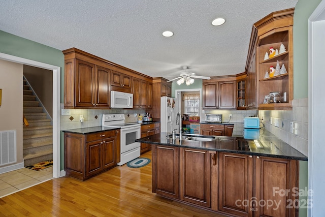 kitchen with kitchen peninsula, sink, ceiling fan, light hardwood / wood-style floors, and white appliances