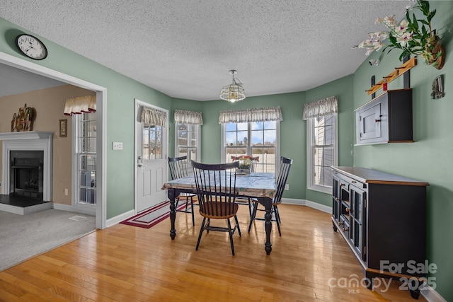 dining space featuring light hardwood / wood-style flooring and a textured ceiling