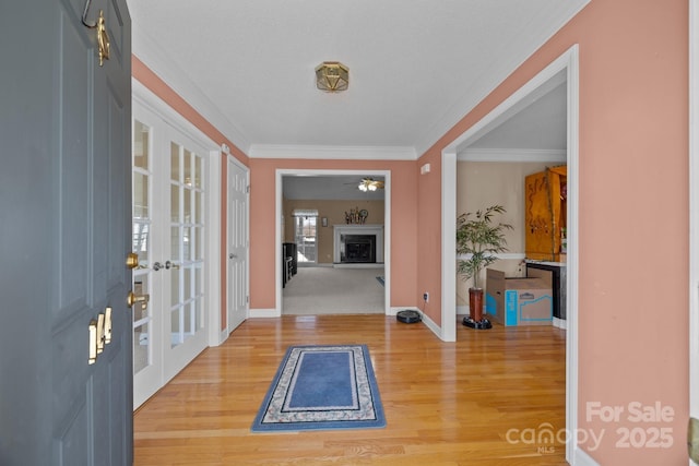 foyer entrance with hardwood / wood-style flooring, ornamental molding, and french doors