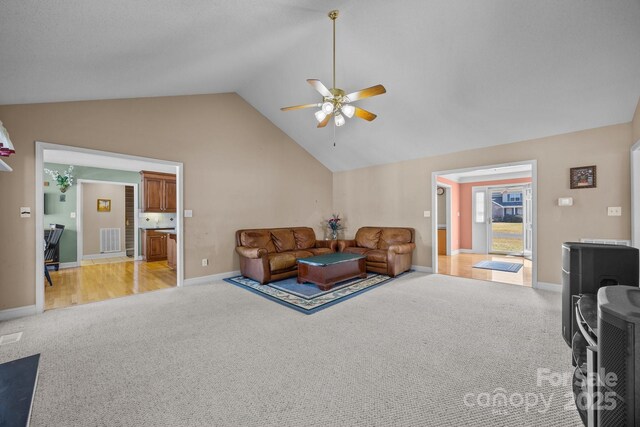 living room with ceiling fan, light colored carpet, and high vaulted ceiling