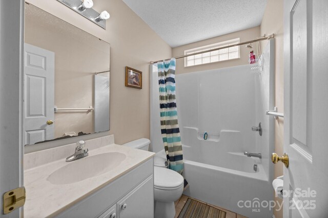 full bathroom featuring vanity, shower / tub combo with curtain, a textured ceiling, and toilet