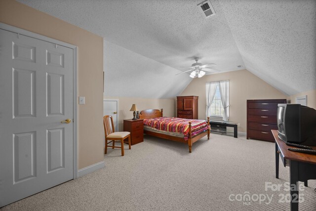 bedroom featuring vaulted ceiling, carpet, ceiling fan, and a textured ceiling
