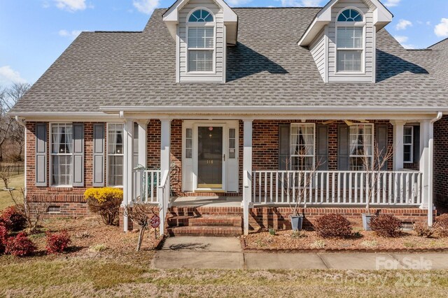 new england style home featuring covered porch