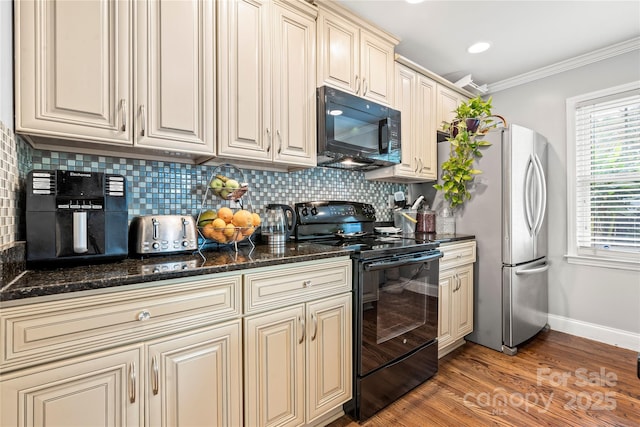 kitchen featuring crown molding, dark stone countertops, tasteful backsplash, cream cabinets, and black appliances