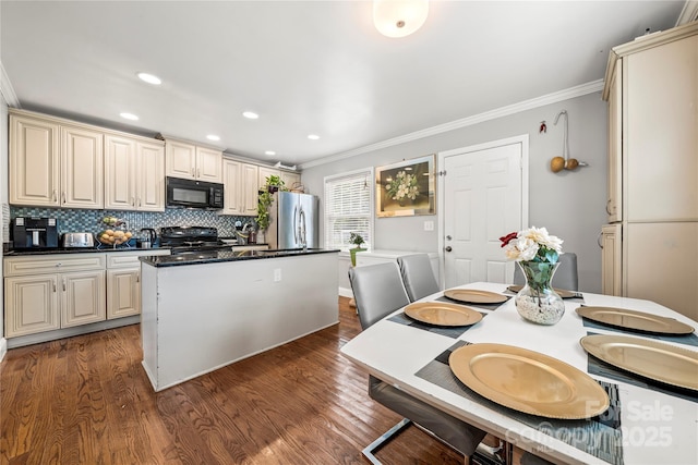 kitchen featuring black appliances, ornamental molding, dark hardwood / wood-style floors, decorative backsplash, and cream cabinetry