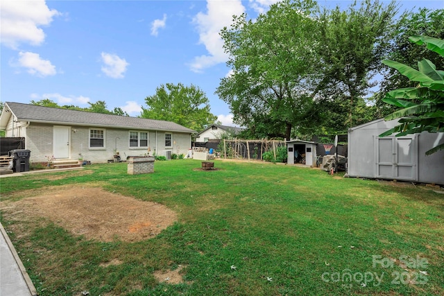 view of yard with an outdoor fire pit and a shed