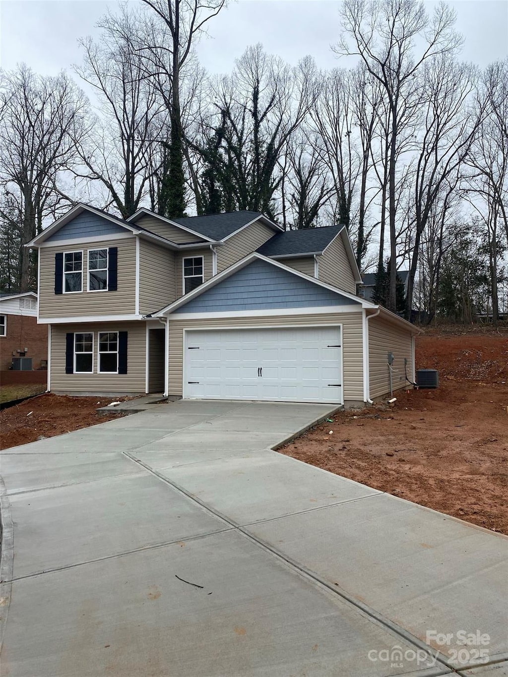 view of front of home featuring a garage and central air condition unit