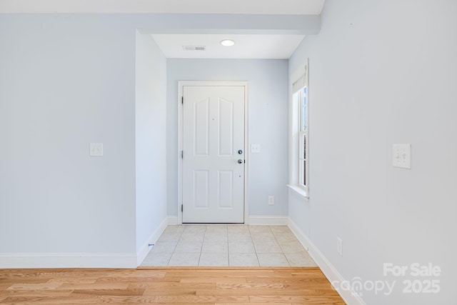 doorway with light wood-style flooring and baseboards