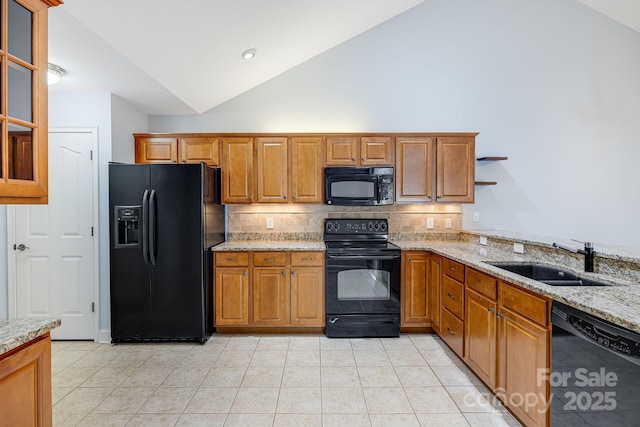 kitchen with light stone countertops, black appliances, a sink, and light tile patterned flooring