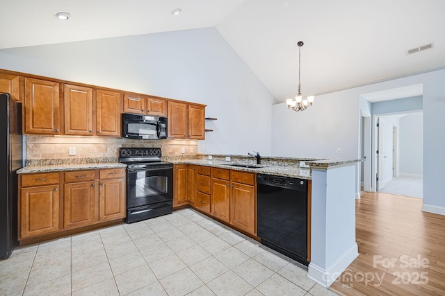 kitchen with black appliances, brown cabinetry, a peninsula, and visible vents