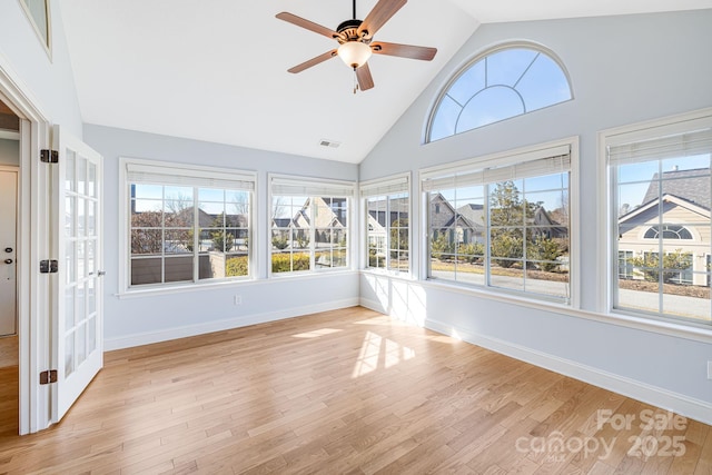 unfurnished sunroom with a ceiling fan, lofted ceiling, a healthy amount of sunlight, and visible vents