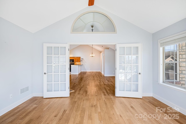 interior space featuring light wood-style floors, baseboards, visible vents, and a chandelier