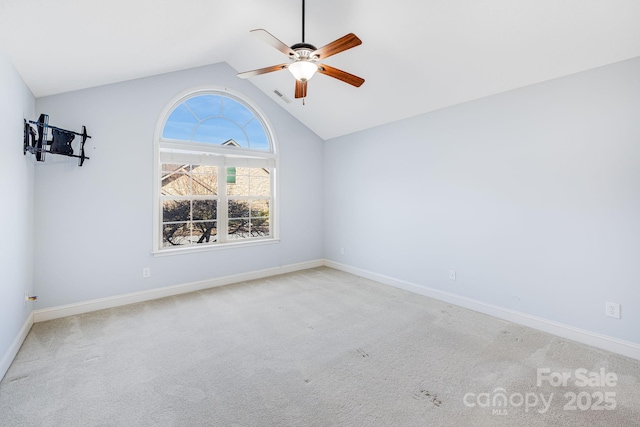 empty room with carpet floors, ceiling fan, visible vents, and baseboards