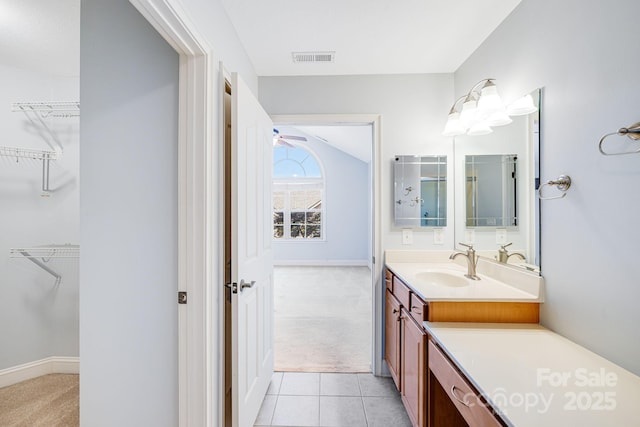 full bathroom featuring vanity, baseboards, visible vents, tile patterned floors, and a walk in closet