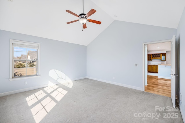 unfurnished bedroom featuring vaulted ceiling, carpet, a ceiling fan, and baseboards