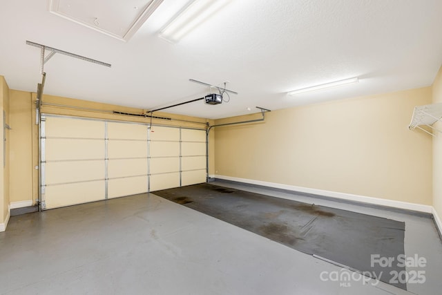 garage with a garage door opener and baseboards