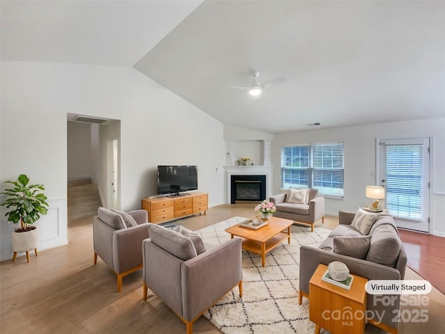 living room with vaulted ceiling, light hardwood / wood-style floors, and ceiling fan