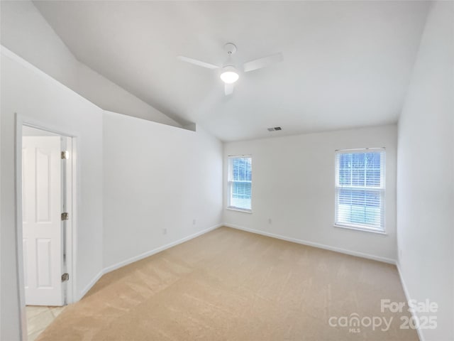 carpeted spare room featuring ceiling fan and lofted ceiling